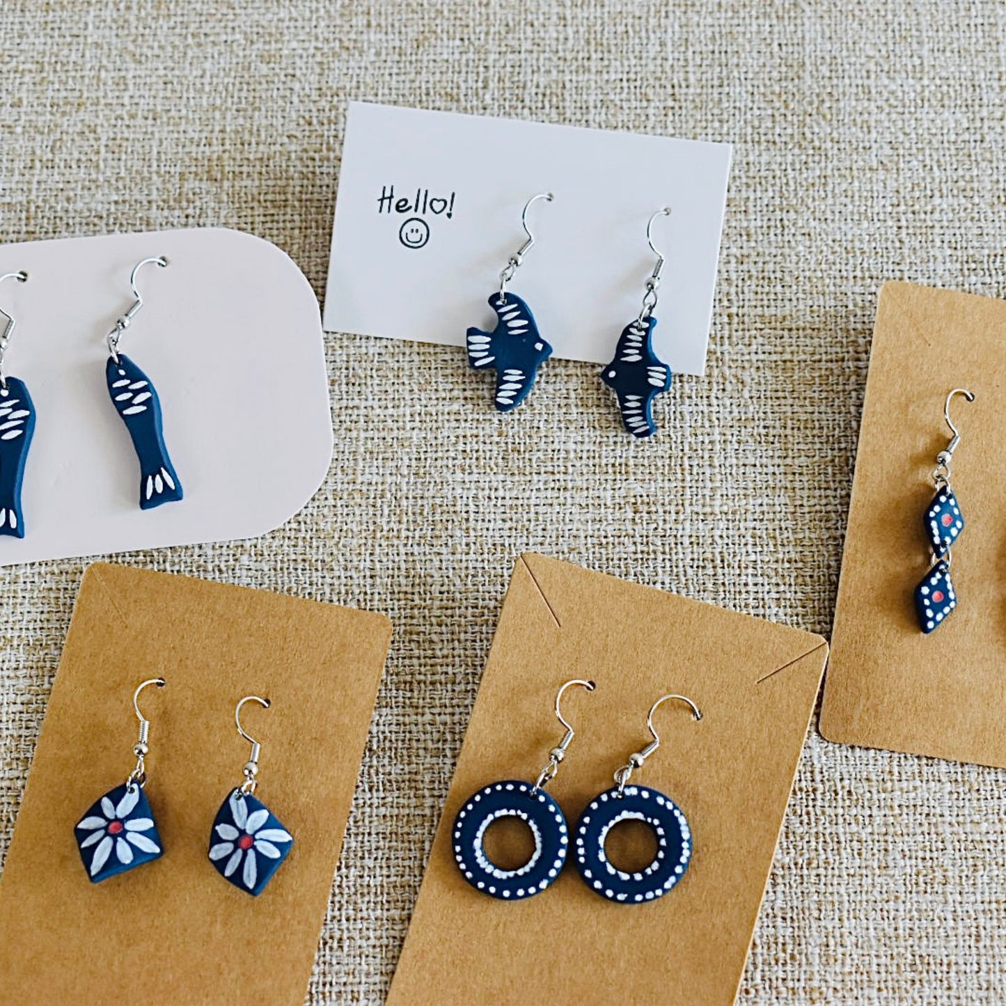 A selection of handmade polymer clay earrings with unique fish, flower, rings and diamonds designs