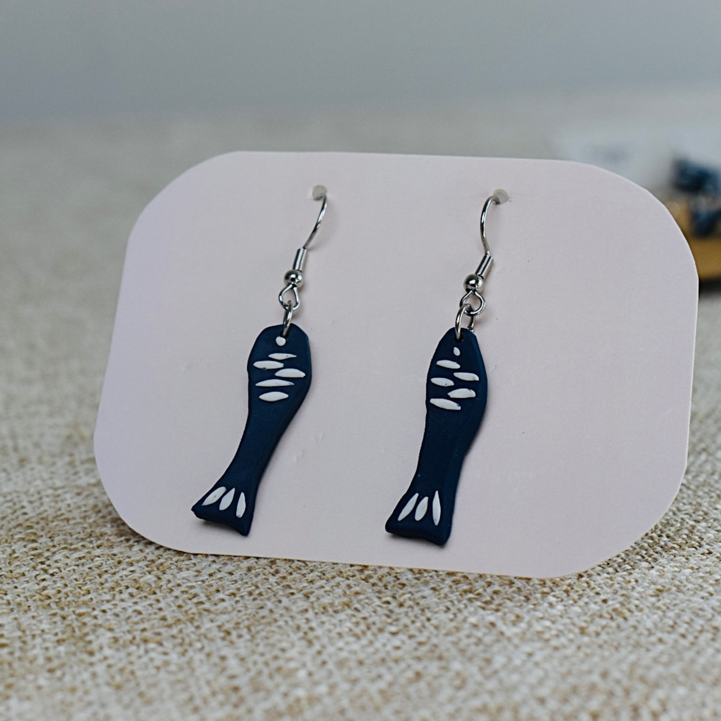 Handmade polymer clay earrings featuring fish design in dark blue