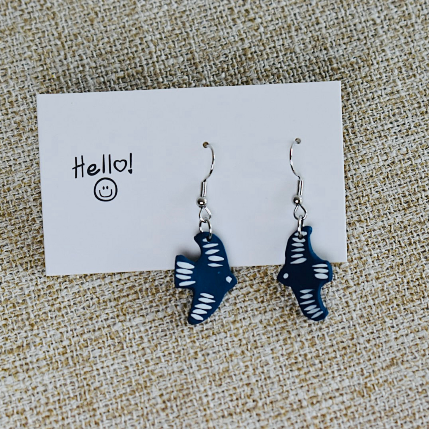 Handmade polymer clay earrings featuring a bird design in blue with white accents
