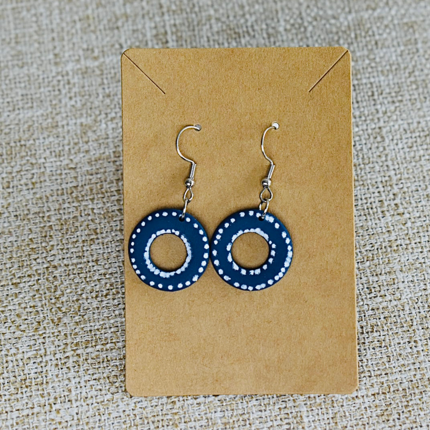 Handmade blue polymer clay earrings with a dotted circular design